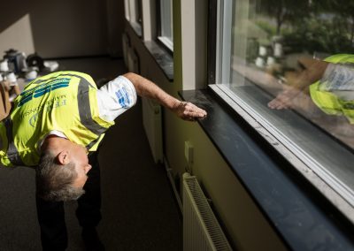 Stefan som besiktigar ett måleri av en vägg inomhus