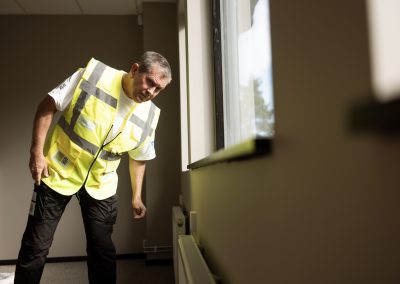 Stefan som besiktigar ett måleri av en vägg inomhus