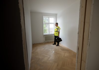 Stefan som besiktigar ett måleri av en vit vägg inomhus