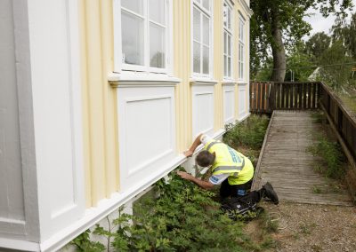 Stefan som besiktigar ett måleri av en gul vägg utomhus